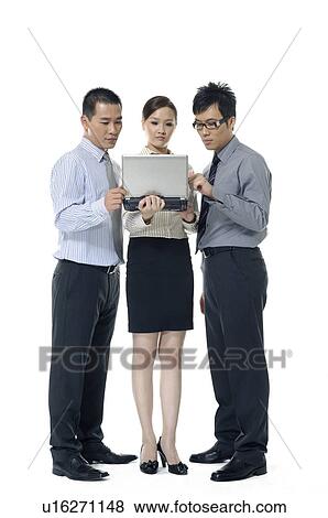 Stock Photo - Two businessmen and a businesswoman working on laptops. Fotosearch