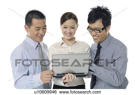 Two businessmen and a businesswoman working on laptops View Large Photo Image Stock Photograph - Two businessmen and a businesswoman working on laptops. Fotosearch