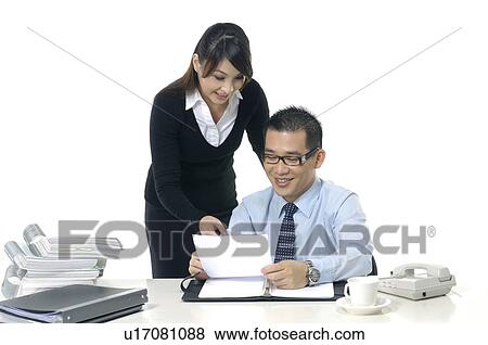 Businessman and a businesswoman discussing a document View Large Photo Image Stock Photo - Businessman and a businesswoman discussing a document. Fotosearch