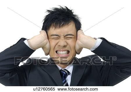 Stock Photography - Businessman covering his ears and clenching his teeth. Fotosearch