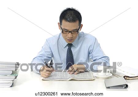 Stock Image - Businessman reading a financial newspaper. Fotosearch