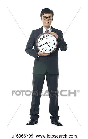 Stock Photo - Businessman showing a clock. Fotosearch