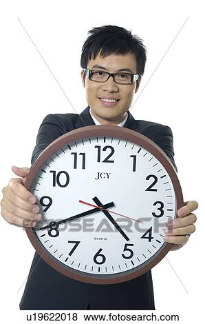 Stock Photo - Businessman showing a clock. Fotosearch
