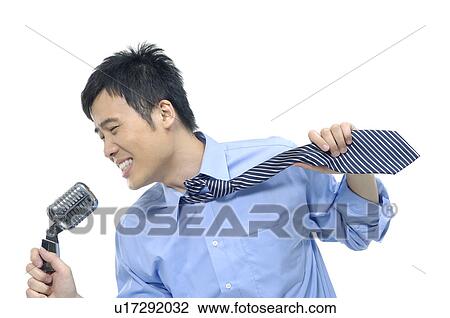 Stock Image - Businessman singing into a microphone. Fotosearch