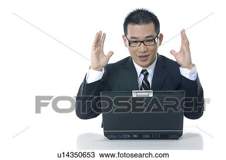 Businessman working on a laptop and raising his hands View Large Photo Image Stock Image - Businessman working on a laptop and raising his hands. Fotosearch