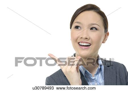 Stock Image - Businesswoman raising her index finger and smiling. Fotosearch