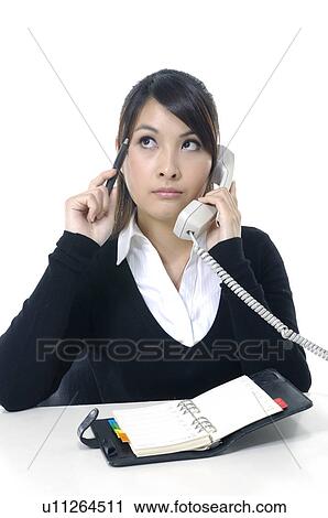 Stock Image - Businesswoman talking on a landline telephone. Fotosearch