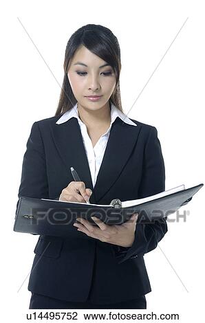 Stock Image - Businesswoman writing on a file. Fotosearch