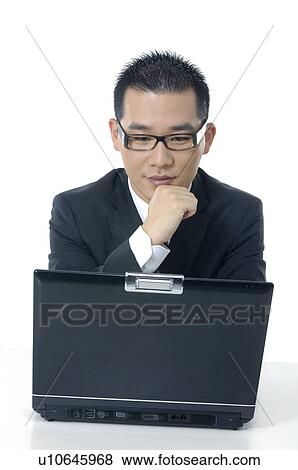 Stock Photo - Pensive businessman looking at a laptop. Fotosearch