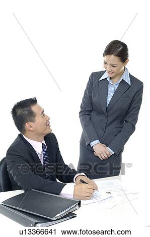 Businessman and a businesswoman discussing a document View Large Photo Image Stock Image - Businessman and a businesswoman discussing a document. Fotosearch