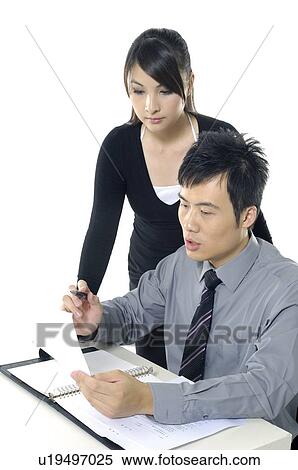 Businessman and a businesswoman discussing a document View Large Photo Image Stock Photography - Businessman and a businesswoman discussing a document. Fotosearch