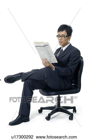 Stock Image - Businessman reading a financial newspaper. Fotosearch