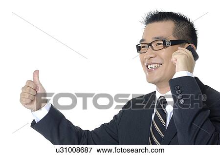 Stock Photo - Businessman talking on a mobile phone and showing thumbs up. Fotosearch
