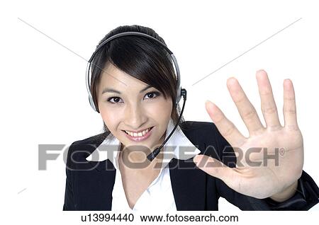 Stock Image - Portrait of a female customer care executive showing stop sign. Fotosearch