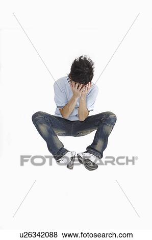 Stock Photo - Young man jumping in mid-air and covering eyes with hands. Fotosearch