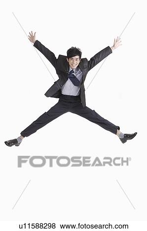 Young man jumping in mid-air with arms outstretched and legs apart View Large Photo Image Stock Photo - Young man jumping in mid-air with arms outstretched and legs apart. Fotosearch
