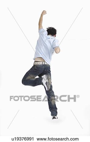 Stock Image - Young man jumping with fist up. Fotosearch