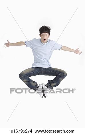 Young man jumping with mouth open and arms outstretched View Large Photo Image Picture - Young man jumping with mouth open and arms outstretched. Fotosearch