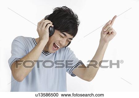 Stock Image - Young man listening to music and laughing. Fotosearch
