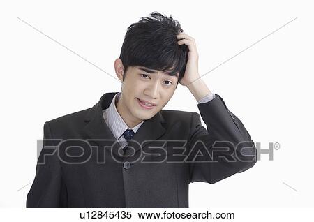 Stock Photography - Young man looking at the camera with hand in hair. Fotosearch