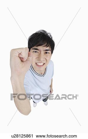 Young man looking up with fist up View Large Photo Image Stock Image - Young man looking up with fist up. Fotosearch