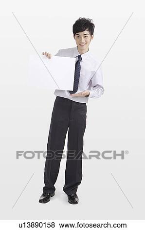 Young man pointing at a sign and smiling View Large Photo Image Stock Photo - Young man pointing at a sign and smiling. Fotosearch