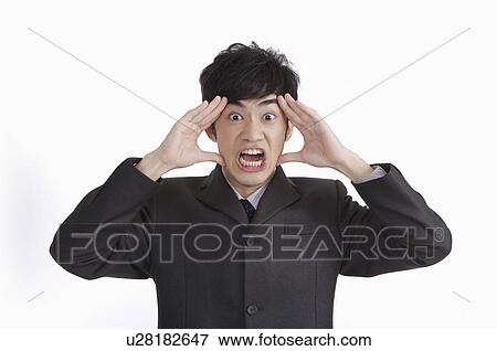 Stock Photo - Young man shocking with mouth open and head in hands. Fotosearch