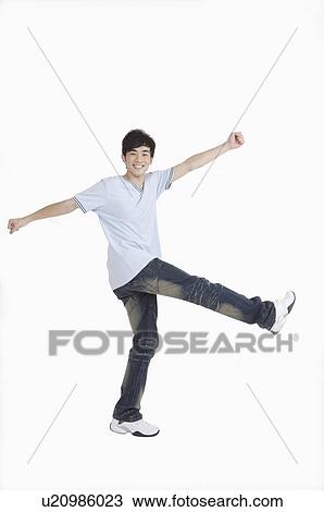 Young man walking with arms outstretched and smiling View Large Photo Image Stock Image - Young man walking with arms outstretched and smiling. Fotosearch