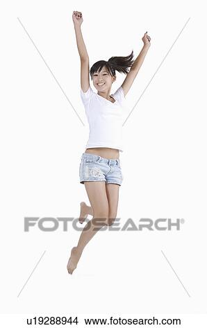 Young woman jumping in mid-air with arms outstretched and smiling View Large Photo Image Picture - Young woman jumping in mid-air with arms outstretched and smiling. Fotosearch