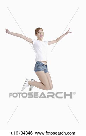Young woman jumping in mid-air with excitement View Large Photo Image Stock Photograph - Young woman jumping in mid-air with excitement. Fotosearch