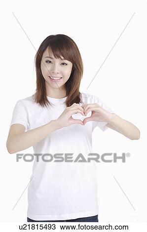 Young woman making heart shape with hands and smiling View Large Photo Image Stock Image - Young woman making heart shape with hands and smiling. Fotosearch