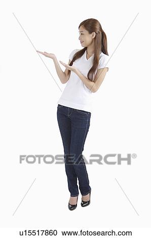 Young woman pointing away and smiling View Large Photo Image Stock Image - Young woman pointing away and smiling. Fotosearch