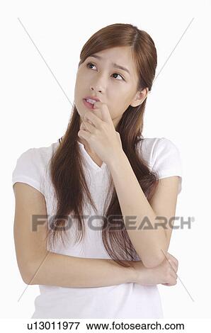 Young woman putting finger on lips and looking away for thinking View Large Photo Image Stock Photo - Young woman putting finger on lips and looking away for thinking. Fotosearch