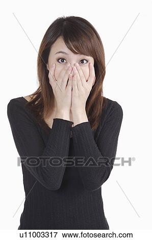 Young woman shocking with hands on mouth View Large Photo Image Stock Photo - Young woman shocking with hands on mouth. Fotosearch