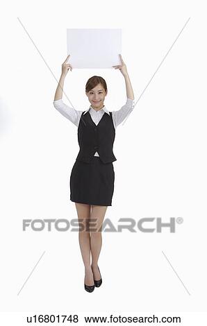 Stock Photo - Young woman standing and lifting a sign with smile. Fotosearch