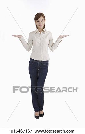 Young woman standing and shrugging with smile View Large Photo Image Stock Photo - Young woman standing and shrugging with smile. Fotosearch