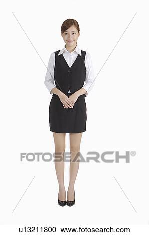 Young woman standing with hands folded in front and smiling View Large Photo Image Stock Image - Young woman standing with hands folded in front and smiling. Fotosearch