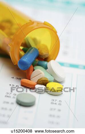Stock Photo - Close-up of pills of different color and pill bottle on a medical report. Fotosearch