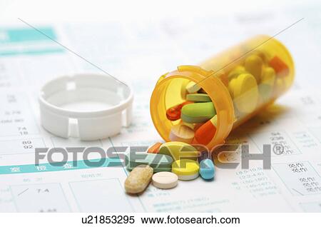Stock Photography - Close-up of tablets and pill bottle on a report. Fotosearch