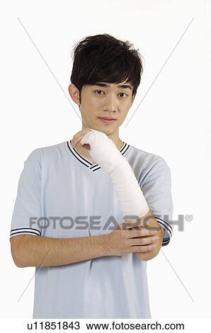 Young man having adhesive bandage on broken arm View Large Photo Image Stock Image - Young man having adhesive bandage on broken arm. Fotosearch