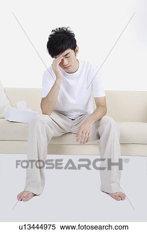 Young man having headache and frowning View Large Photo Image Stock Photography - Young man having headache and frowning. Fotosearch