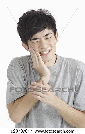 Young man having toothache with hand on chin View Large Photo Image Stock Photo - Young man having toothache with hand on chin. Fotosearch