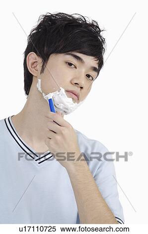 Young man shaving with soap suds and looking at the camera View Large Photo Image Stock Photography - Young man shaving with soap suds and looking at the camera. Fotosearch