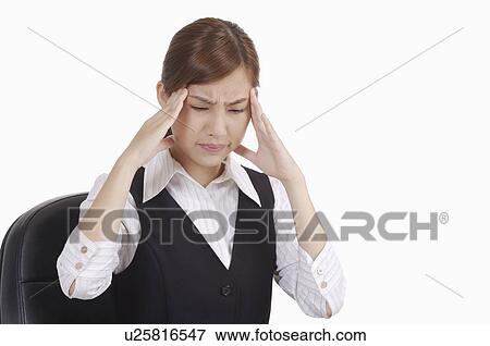 Stock Photo - Young office lady frowning with hand on head of headache. Fotosearch
