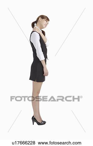 Stock Photo - Young office lady standing and massaging shoulder. Fotosearch