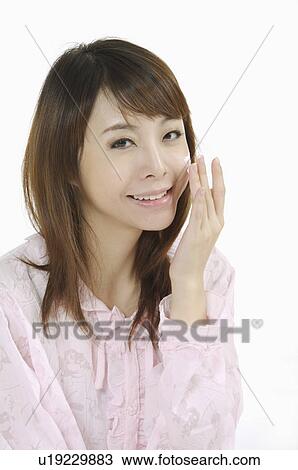 Young woman applying lotion on face and smiling at the camera View Large Photo Image Stock Image - Young woman applying lotion on face and smiling at the camera. Fotosearch