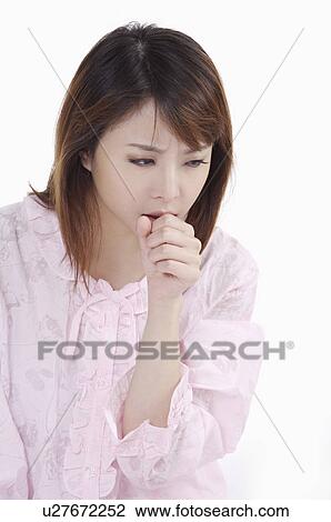 Stock Image - Young woman coughing and looking away. Fotosearch