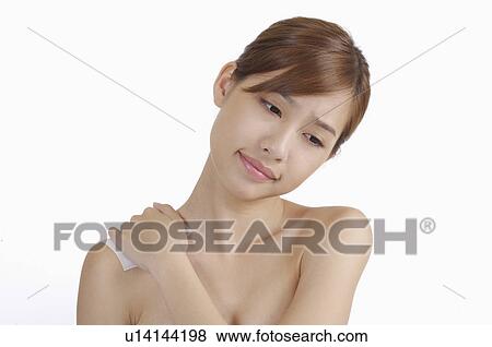Stock Photo - Young woman frowning and putting hand on shoulder. Fotosearch