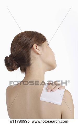 Young woman sticking medicine on shoulder View Large Photo Image Stock Photography - Young woman sticking medicine on shoulder. Fotosearch