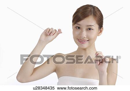 Stock Photography - Young woman using dental floss and smiling at the camera. Fotosearch